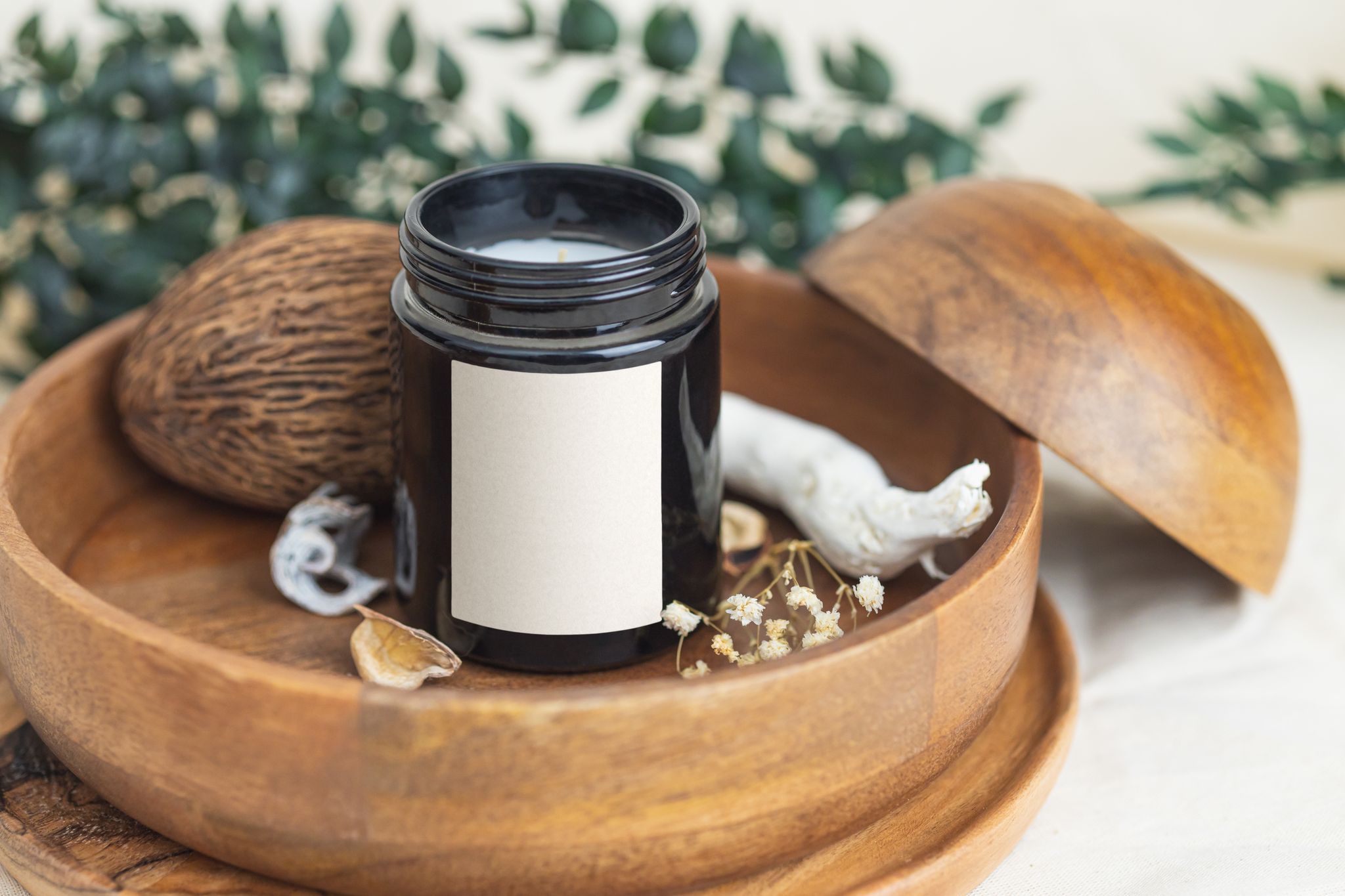 Elegant scented candle in a wooden bowl with aromatic elements, ideal for relaxation.